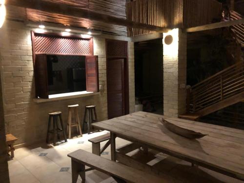 a wooden table in a room with a television and stools at Casa los Almendros in Guamo
