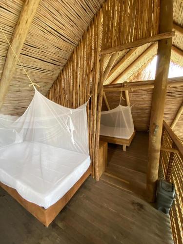 an attic room with two beds and a net at Casa los Almendros in Guamo