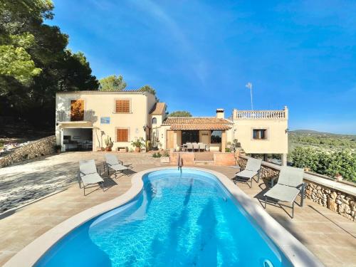 a villa with a swimming pool in front of a house at es cau in Manacor