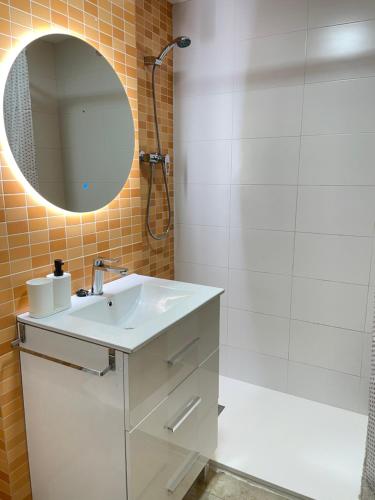 a bathroom with a sink and a shower and a mirror at UIM Mediterraneo PB Felipe 2 Wifi in Puerto de Sagunto