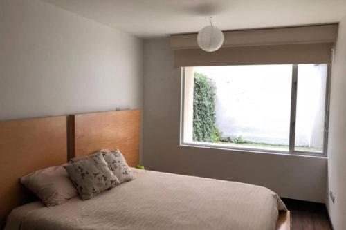 a bedroom with a bed with a large window at 1430 Luxury Suite Edificio Avadell- Bellavista-Quito in Quito
