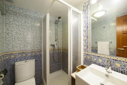 een badkamer met een toilet, een douche en een wastafel bij El Jardín del Ángel Olivo in Madrid