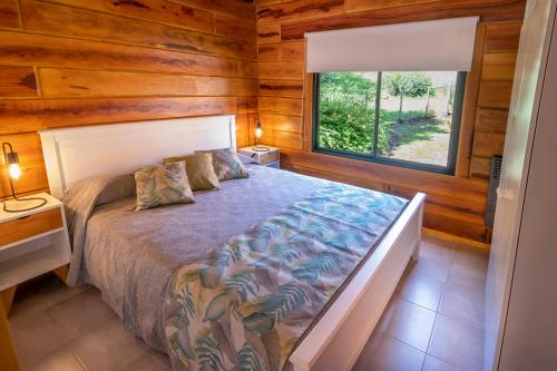 um quarto com uma cama num quarto com uma janela em Monviso - Casas de montaña em Santa Rosa de Calamuchita