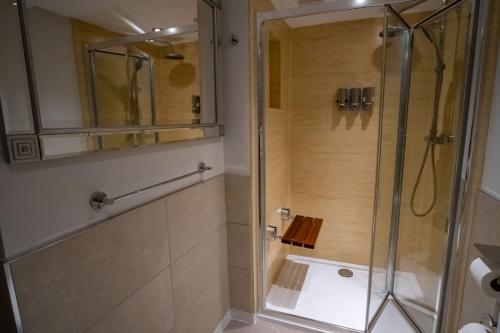 a shower with a glass door in a bathroom at Magnolia House, Rye in Rye