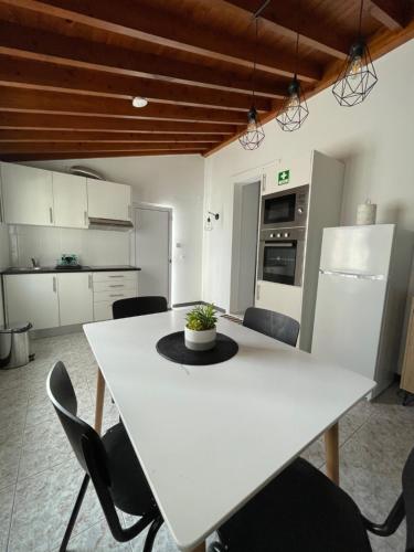 a kitchen with a white table and chairs at Arco´s Apartment 2 in Ponta Delgada