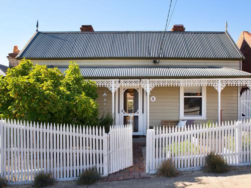 a white picket fence in front of a house at Albert Cottage - charming miner's cottage in town in Daylesford