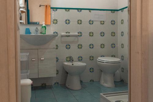 a bathroom with a toilet and a sink at La Casa del Limoneto in Favignana