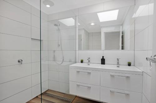a white bathroom with a shower and a sink at Becca's on Burke in Bright