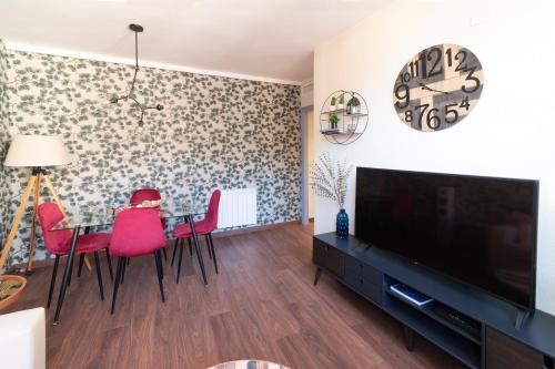 a living room with a table and chairs and a television at Arista Huesca in Huesca