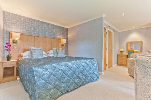 a hotel room with a bed and a dresser at Ambleside Salutation Hotel & Spa, World Hotel Distinctive in Ambleside