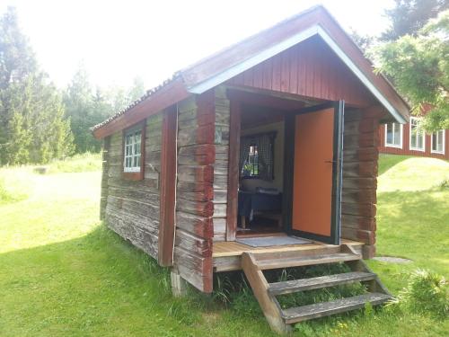 a small log cabin with a staircase leading to the door at Kullsbjörken Bed & Breakfast in Tällberg