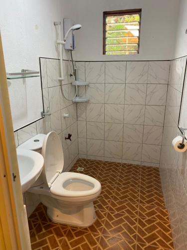 a bathroom with a toilet and a sink at One 4 Da Road in Panglao