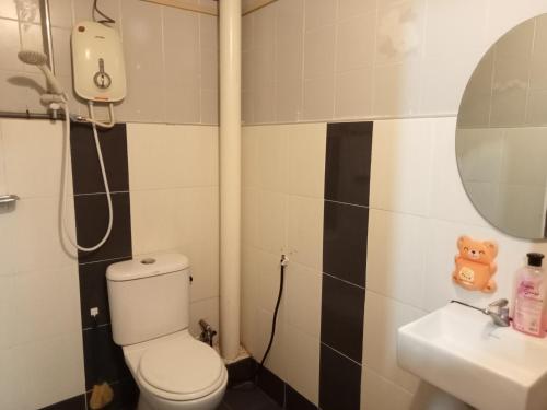 a bathroom with a toilet and a sink at ROSSA Condo 1 in Kuah