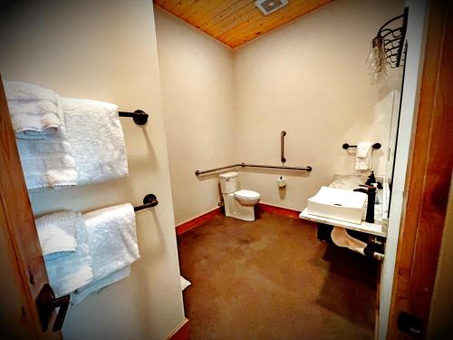 a bathroom with a toilet and a sink and towels at Enchantment Lodges - 5 min walk to downtown in Leavenworth