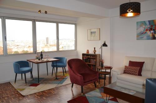 a living room with a couch and a table and chairs at Tagus Life Areeiro in Lisbon