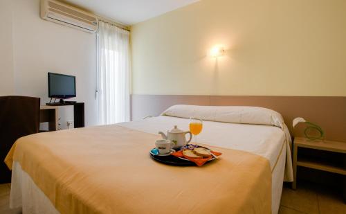 a hotel room with a bed with a tray of food and drinks at Hotel Felix in Lorca