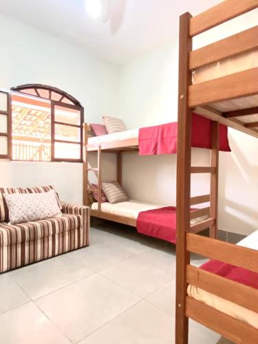 a room with two bunk beds and a couch at Casa 105 in Arraial do Cabo