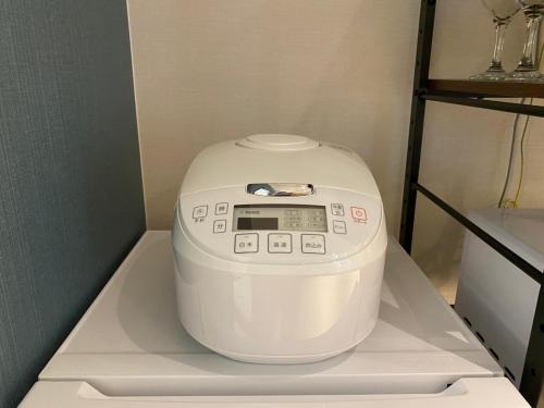 a washing machine sitting on top of a shelf at ホテルトーマス前島 in Naha
