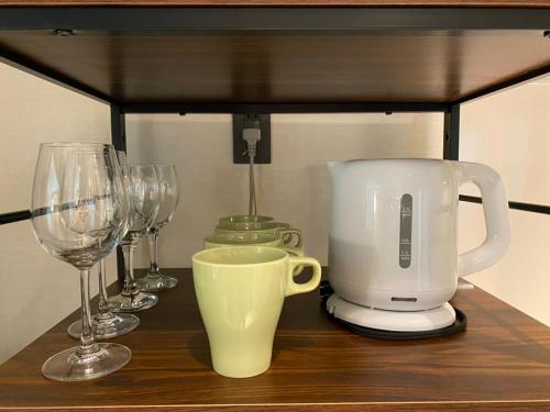 a counter with wine glasses and a coffee maker at ホテルトーマス前島 in Naha
