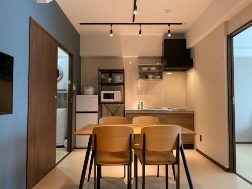 a kitchen and dining room with a table and chairs at ホテルトーマス前島 in Naha