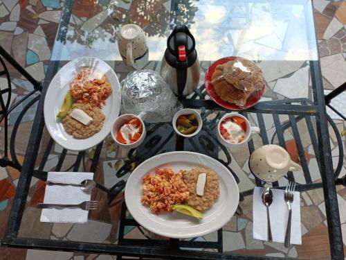 a glass table with two plates of food on it at HOTEL CASA LIMON in Santa Rosa de Jáuregui