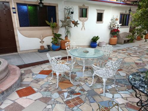 a patio with a table and chairs on a mosaic floor at HOTEL CASA LIMON in Santa Rosa de Jáuregui