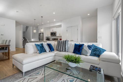 a white living room with a white couch and blue pillows at Luxury Spacious Private House near City Centre in Calgary