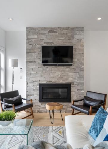 a living room with a fireplace with a flat screen tv at Luxury Spacious Private House near City Centre in Calgary