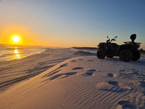 a quad bike parked on the beach at sunset at Resort GoldenLake em Arraial do Cabo in Arraial do Cabo