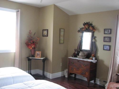 a bedroom with a dresser and a mirror on the wall at Argyle By The Sea Bed & Breakfast in Pubnico