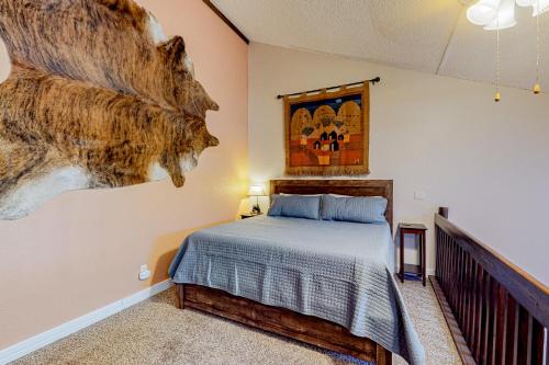 ein Schlafzimmer mit einem Bett und einem Wandgemälde in der Unterkunft Buffalo Beauty in Granby