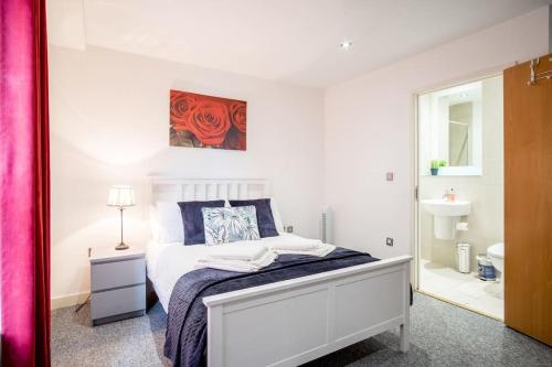 - une chambre blanche avec un lit et un miroir dans l'établissement Large 2 Bed, 2 Bath, Free Parking & WiFi, à Sheffield