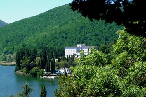 a large building sitting on the side of a river at Hotel Del Lago Piediluco Active & SPA in Piediluco