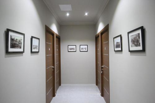 a hallway with wooden doors and pictures on the wall at Kantar Hotel in Yerevan