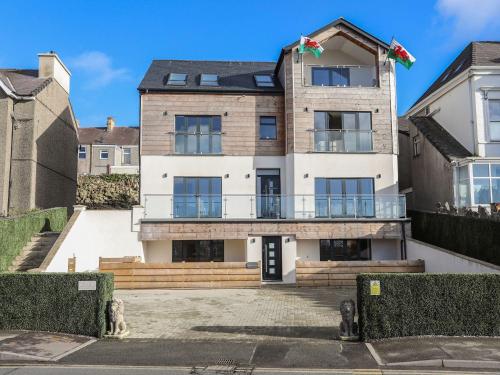 a large white house with a balcony at Bryn Min Manton Apartment in Caernarfon