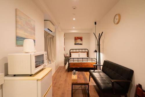 a living room with a couch and a bed at Yeah Room Namba in Osaka