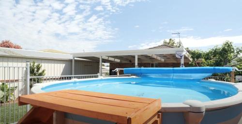 a large pool with a wooden table and a picnic table at Coastal Springs - PET FRIENDLY & 200m To Beach! in Clifton Springs