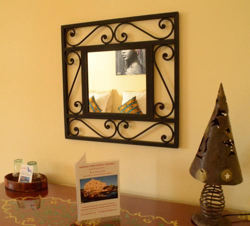 a mirror on a wall with a christmas tree on a table at Dar Essaada in Essaouira