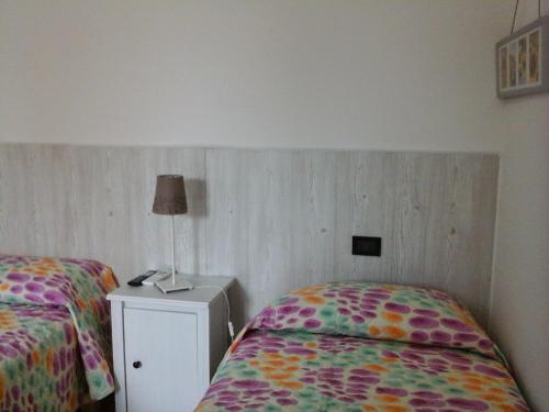 a bedroom with two beds and a lamp on a night stand at La Casa di Linda in Mirano