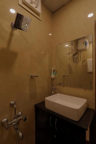 a bathroom with a sink and a mirror at Shri Tirupati Residency in Nilmatha