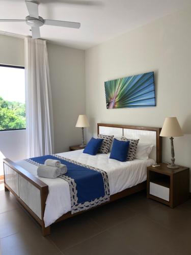 sypialnia z dużym łóżkiem z niebieskimi poduszkami w obiekcie Penthouse 3 chambres Vue Lagon imprenable w mieście Calodyne