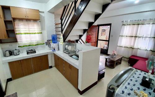 una cocina con fregadero y un sofá en una habitación en Kaitleen Home Stay Door 3, en Tacloban