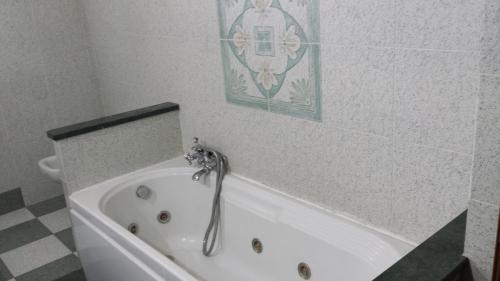 bañera blanca en el baño con una foto en la pared en Villa Giuliana, en Anguillara Sabazia