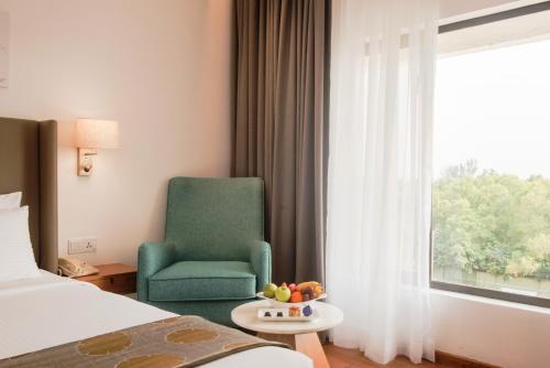 a hotel room with a chair and a window at Vivanta Colombo, Airport Garden in Negombo
