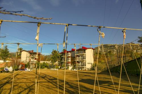 a view of an apartment complex from behind a net at Excel Hotels and Resorts Bhimtal in Bhīm Tāl