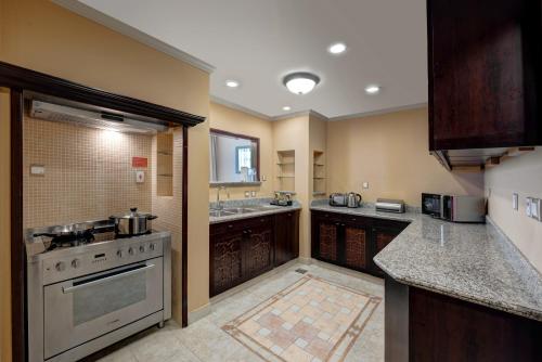 a large kitchen with a stove and a sink at Arjaan by Rotana - Dubai Media City in Dubai