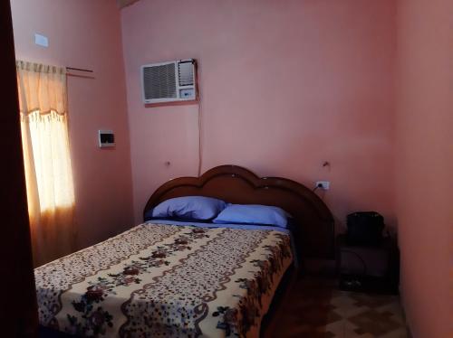 1 dormitorio con 1 cama en una habitación con paredes rosas en Casa con piscina en Gobernador Roca en Gobernador Roca