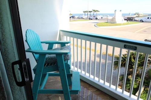 uma cadeira azul sentada numa varanda com vista para o oceano em Beachfront View Condo at Casa Del Mar em Galveston