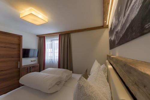 a hotel room with a bed and a television at The Lodge by Regina in Sölden