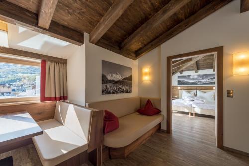 ゼルデンにあるRegina's Alpenlodgeのソファ、ベッド、窓が備わる客室です。